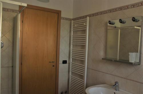 een badkamer met een wastafel en een douche met een spiegel bij Da Ginetto Assisi in Petrignano