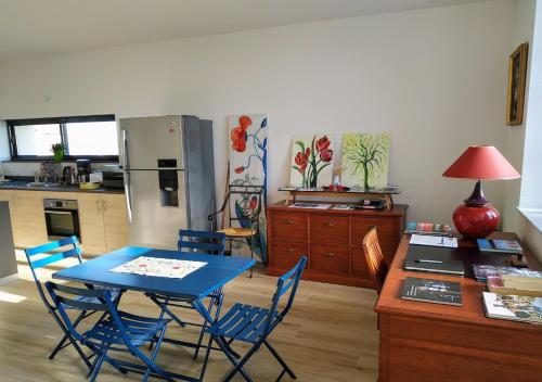 La cuisine est équipée d'une table bleue, de chaises et d'un réfrigérateur. dans l'établissement Chambres d'Hôtes La Courlande, à Saint-Haon-le-Vieux