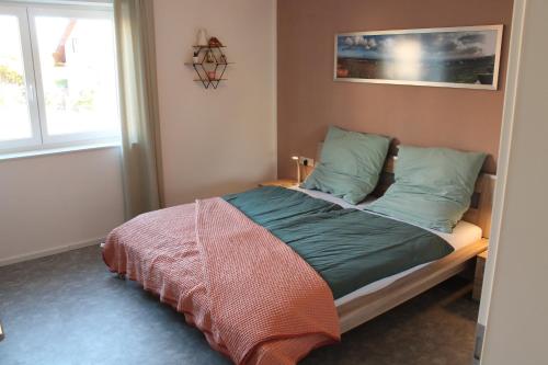 a bedroom with a bed with green pillows and a window at Ferienwohnung Andergasse in Neustadt an der Weinstraße