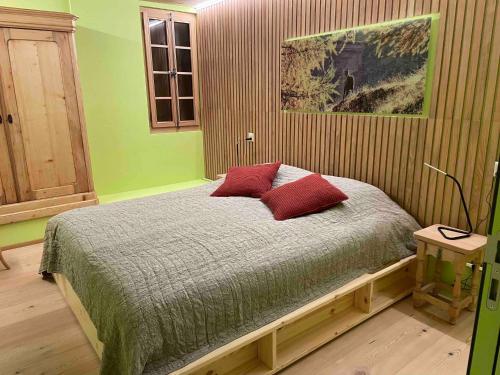 1 dormitorio con 1 cama con 2 almohadas rojas en Appartement for Holiday Lodge 1891 en Stalden