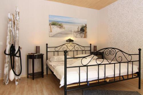 ein Schlafzimmer mit einem Bett und einem Bild von einem Strand in der Unterkunft Apartment, Vogelsang-Warsin in Vogelsang