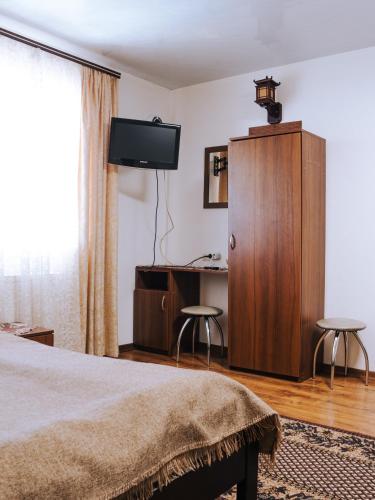 a bedroom with a bed and a cabinet and a television at Filvarok Hotel in Brody