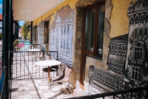 a balcony with a table and chairs on a building at Filvarok Hotel in Brody