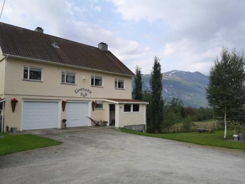 een wit huis met een garage en een oprit bij Elvebakk Bed & Breakfast in Reed