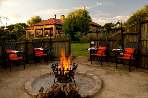 a fire pit in a yard with chairs and tables at Boubou Bed and Breakfast in Rustenburg