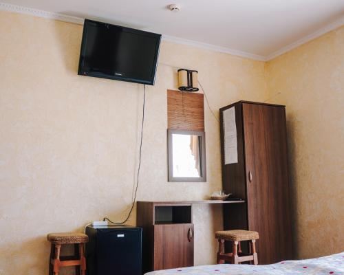 a room with a tv on the wall with two stools at Filvarok Hotel in Brody