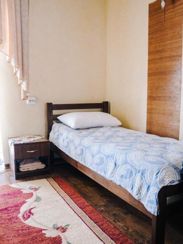 a bedroom with a bed and a nightstand next to it at Filvarok Hotel in Brody
