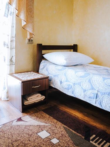 a bedroom with a bed with a nightstand next to it at Filvarok Hotel in Brody