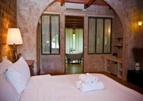 a bedroom with a bed with towels on it at La Toscana in Suan Phung