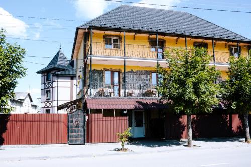 a house with a red fence in front of it at Filvarok Hotel in Brody