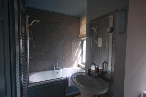 a bathroom with a sink and a bath tub and a sink at High St Flat in Edinburgh