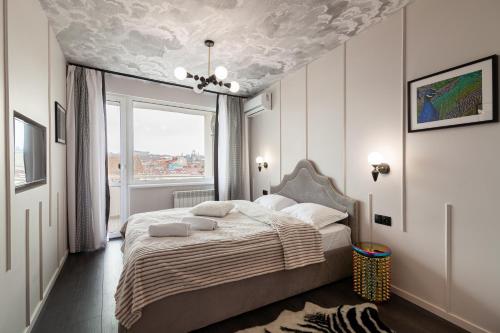 - une chambre avec un lit et un plafond peint de nuages dans l'établissement LEOGRAND Apartments on Svobody avenue, à Lviv