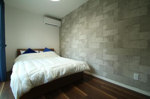 熊本市にあるKumamoto - House - Vacation STAY 89433のレンガの壁とベッドが備わるベッドルーム1室が備わります。