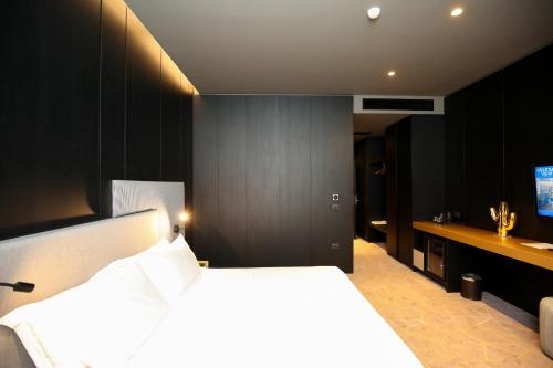 a bedroom with a large bed and a bathroom at The Central View Boutique Hotel in Vlorë