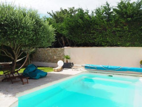 une piscine bleue avec une chaise et des arbres dans l'établissement Holiday Home in Pertuis with Private Pool, à Pertuis