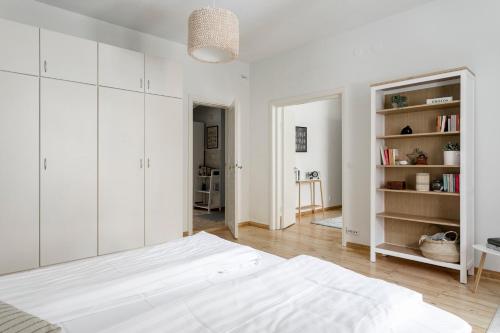 - une chambre blanche avec un lit et une étagère dans l'établissement 2ndhomes Central & Spacious 85m2 apartment in Yrjönkatu, à Helsinki