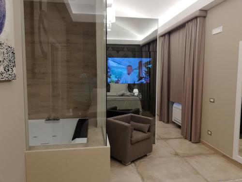 een woonkamer met een stoel en een televisie bij Hotel Parco delle Querce in Crispiano