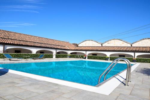 a swimming pool in a courtyard with a building at Hotel Parco delle Querce in Crispiano