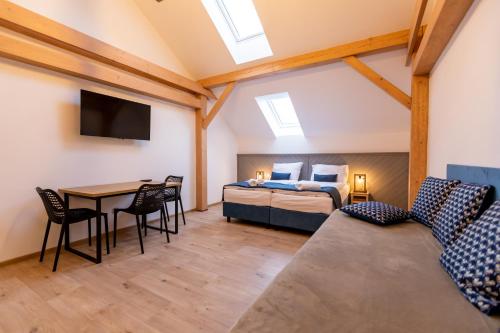 a bedroom with a bed and a table with a couch at Benátky 214 in Vranov nad Dyjí