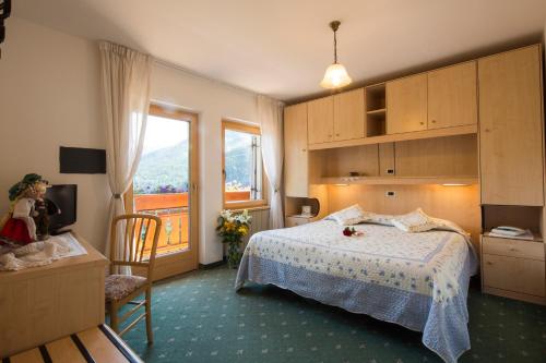 a bedroom with a bed and a large window at Hotel Garni Excelsior in Livinallongo del Col di Lana