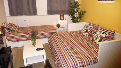 een kleine kamer met 2 bedden en een tafel bij Chez Esmara Et Philippe Fourche in Brussel