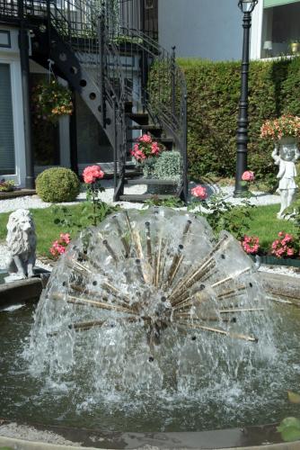 a fountain in the middle of a garden with a water fountain at Hotel Villa am Kurpark in Bad Homburg vor der Höhe