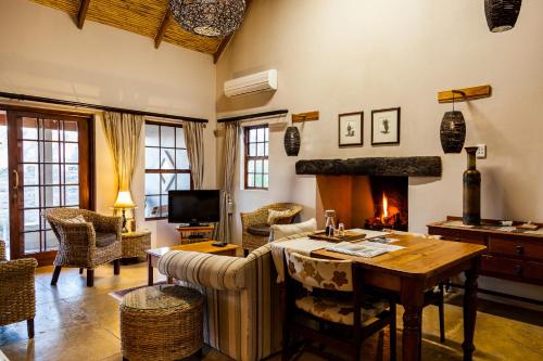 a living room with a table and a fireplace at Karoo View Cottages in Prince Albert