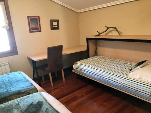 a bedroom with a bed and a desk and a table at Caserio Arrigorri excelente ubicación jardín con barbacoa 14 plazas in Murguía