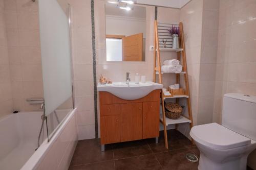 a bathroom with a sink and a toilet and a tub at MilDreams House in Vila Nova de Milfontes