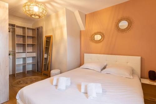 Un dormitorio con una cama blanca con toallas. en DIFY Grillet - Cordeliers, en Lyon