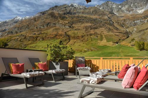 a patio with couches and chairs and a mountain at Residence Panorama Pfelders in Pfelders