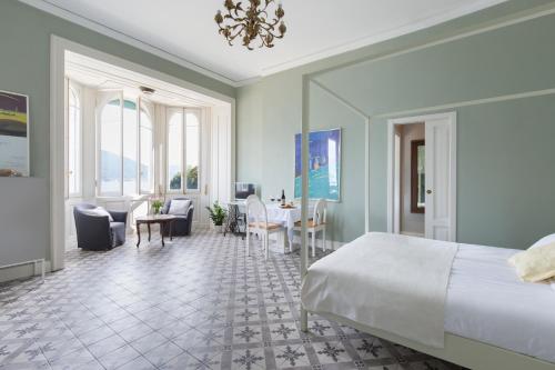 a bedroom with a bed and a table and chairs at Villa Maria Boutique Apartments in Cannobio