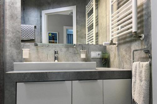 a bathroom with a white sink and a mirror at holiday home, Trzesacz in Trzęsacz