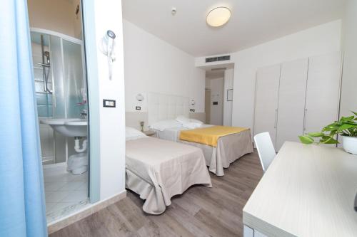 a hospital room with two beds and a sink at Hotel Elite Cattolica in Cattolica