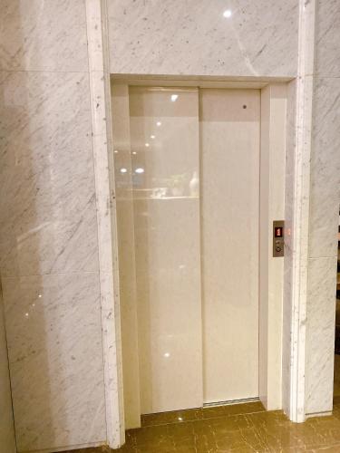 a large glass door in a room with a wall at Homie B&B in Hualien City