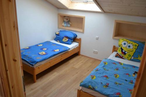 a small bedroom with two beds and a window at Straub / Ferienwohnung Allgäublume in Oy-Mittelberg