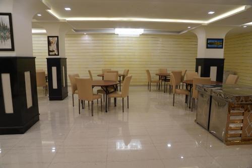 a dining room with wooden tables and chairs at Rama Trident, Katra in Katra