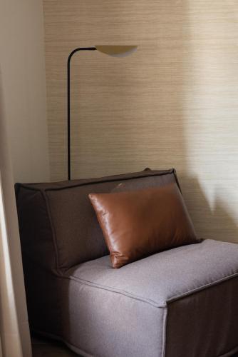 a brown couch with a brown pillow on it at EMA House Serviced Apartments Superior Unterstrass in Zürich