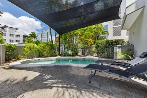 a swimming pool with two chairs and an umbrella at The Penthouse Mooloolaba, Private Luxury Rooftop Living in Mooloolaba
