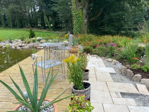 a garden with a bench and a pond with plants at Rathjarney Gatelodge in Wexford