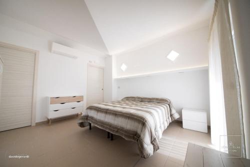 1 dormitorio blanco con 1 cama y vestidor en L'oro dei fiori (Honey spa), en Ripacandida