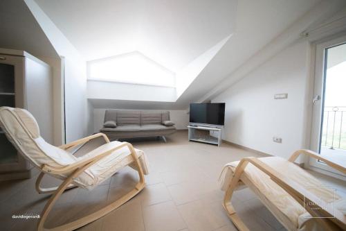 uma sala de estar com duas cadeiras e um sofá em L'oro dei fiori (Honey spa) em Ripacandida