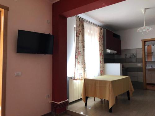 um quarto com uma mesa, uma televisão e uma janela em Casuta Lavi Constanta em Constança
