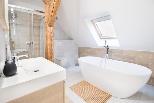 uma casa de banho com uma banheira branca e um lavatório. em U Zlaté hvězdy apartmán Broggio em Litoměřice