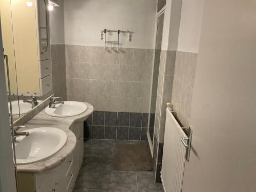 une salle de bain avec deux lavabos et un miroir dans l'établissement La Maison des cressonnières, à Saint-Pardoux-du-Breuil
