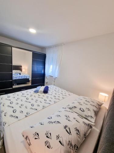 - une chambre avec un grand lit et un miroir dans l'établissement Apartment Ane 2, à Tisno