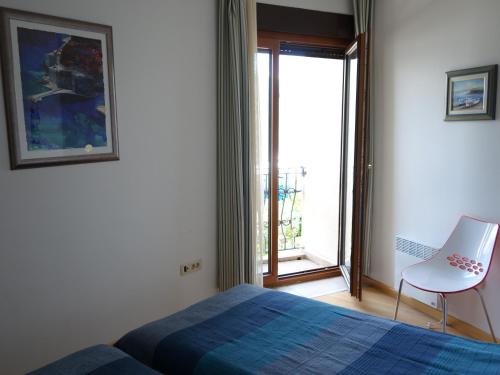 a bedroom with a bed and a chair and a window at Orahovac Bayview in Kotor
