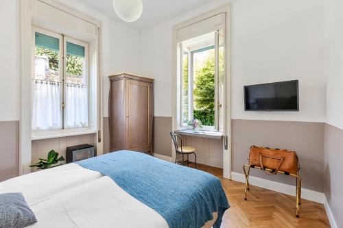 a bedroom with a bed and a tv on a wall at Villa Maria Boutique Hotel in Cannobio