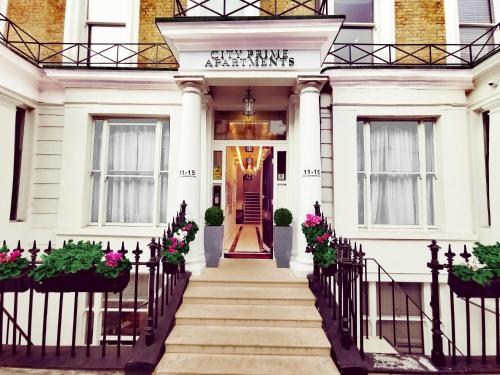 a white house with a staircase leading to the front door at City Prime Apartments in London