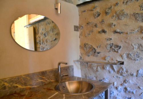 uma casa de banho com um lavatório e um espelho em Maison de 2 chambres avec piscine partagee jardin clos et wifi a Gembrie em Gembrie
